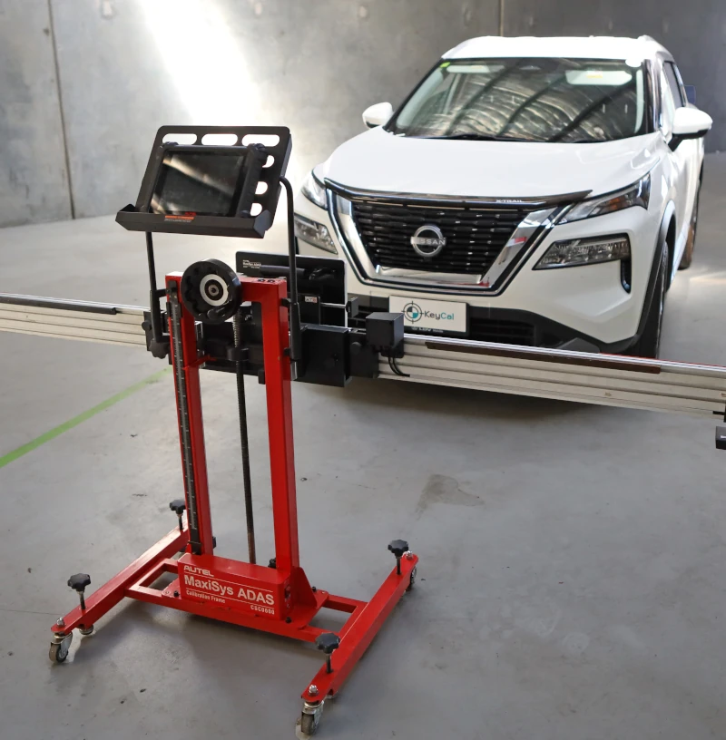 Autel MaxiSys ADAS calibration frame positioned in front of Nissan SUV in workshop