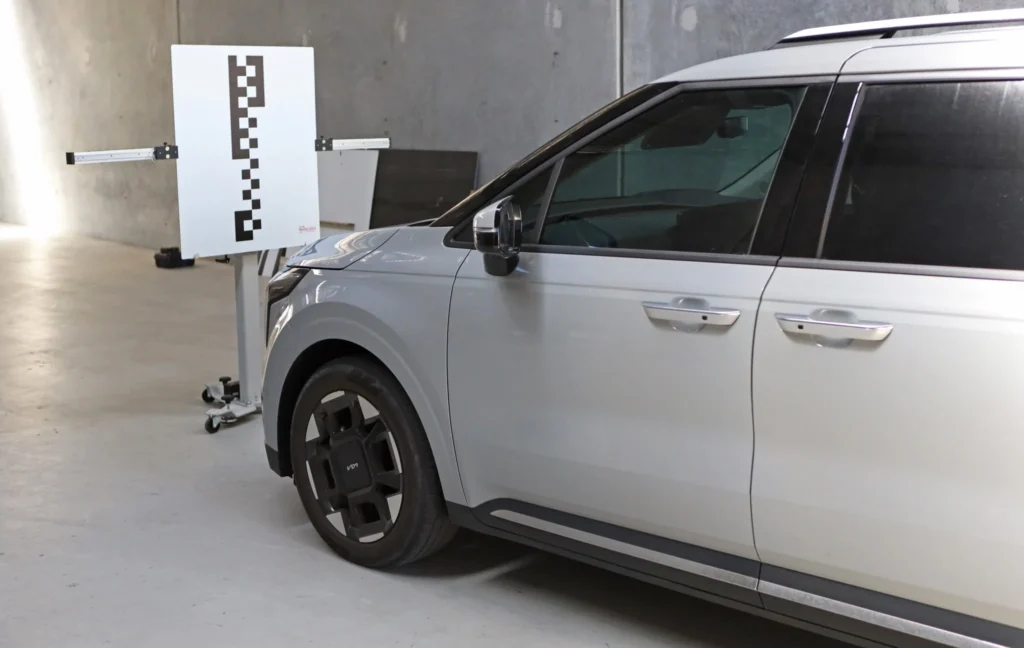 White SUV positioned in front of ADAS calibration target panel