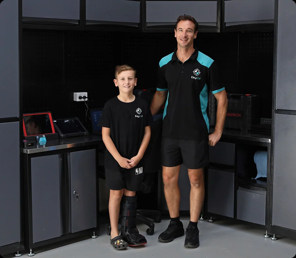 KeyCAL technician standing beside a child in workshop, representing family-run business