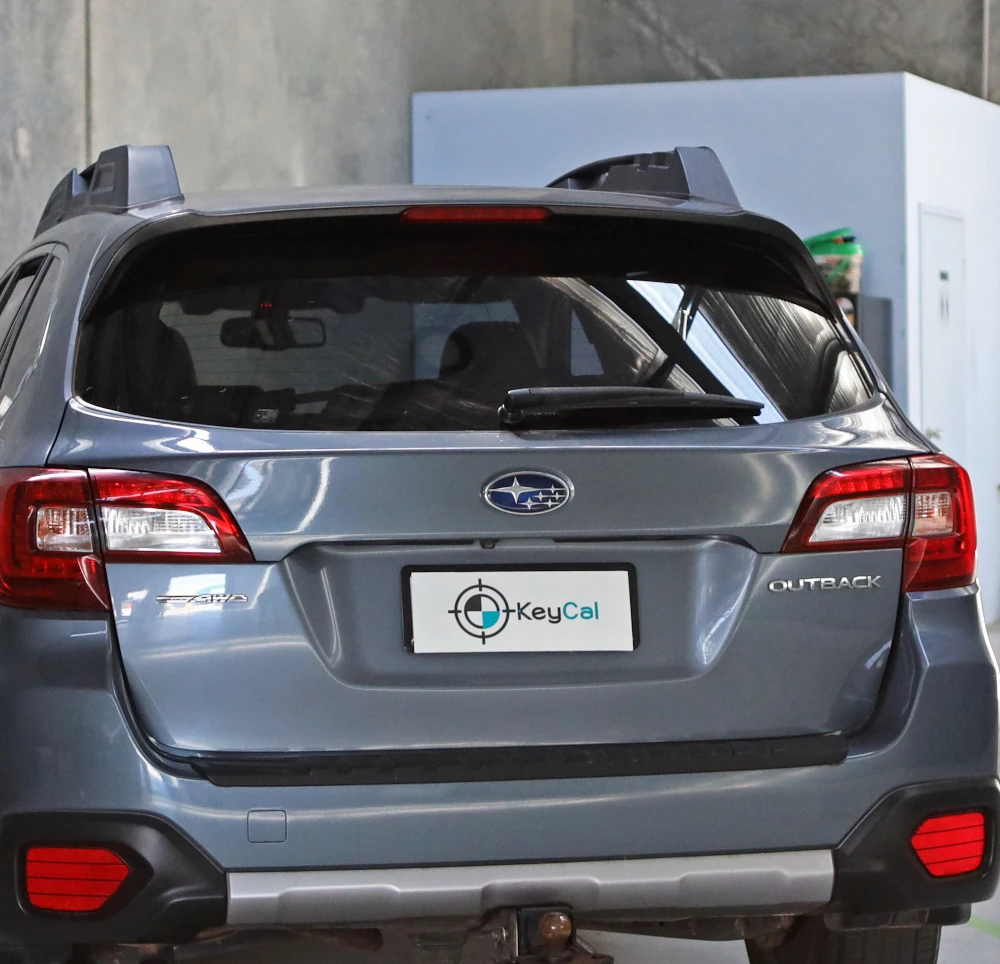 Subaru Outback positioned in KeyCAL workshop displaying branded license plate